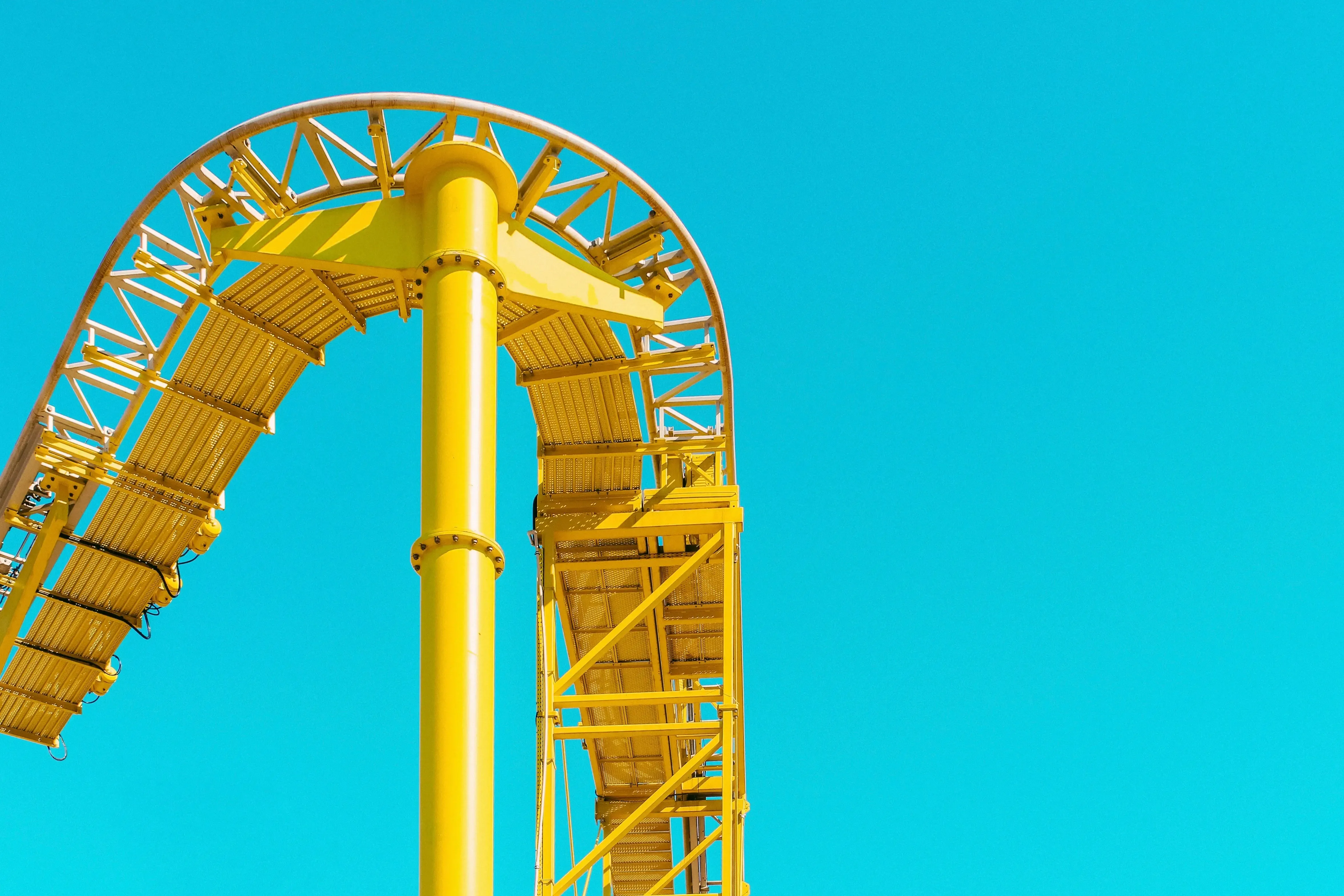 A yellow rollercoaster ride with a blue sky